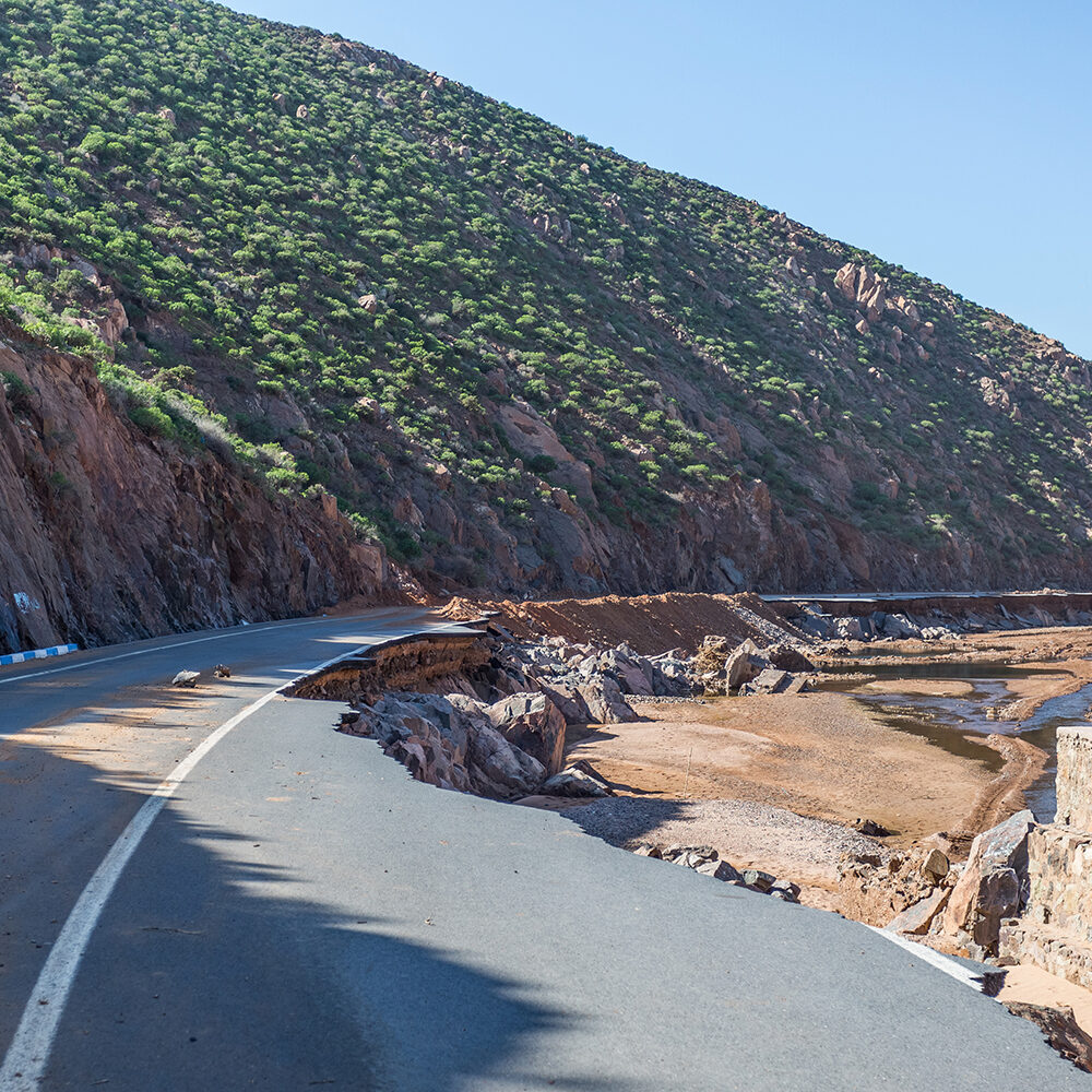 Catástrofe natural. Consecuencias de los flujos de lodo Natural catastrophe. Consequences of mudflows. Destroyed asphalt road in the mountains as a result of a landslide, river spill