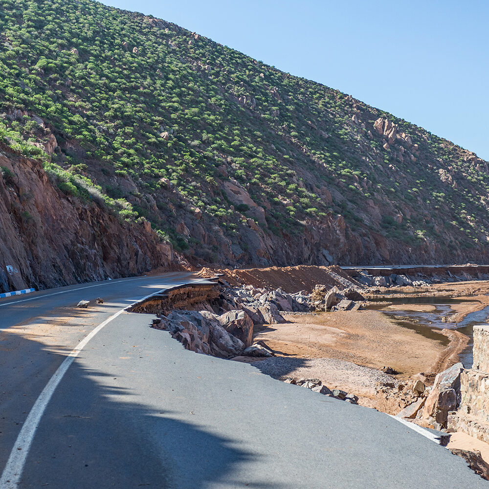 Natural catastrophe. Consequences of mudflows. Destroyed asphalt road in the mountains as a result of a landslide, river spill